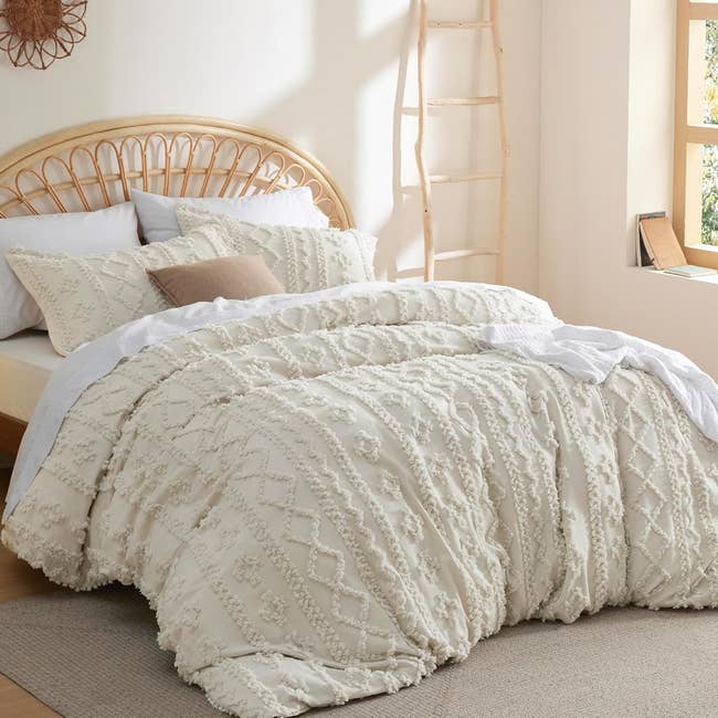 An elegant textured comforter set with decorative pillows on a bed,suitable for a cozy bedroom upgrade