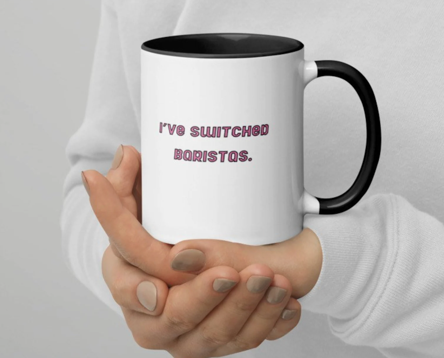 model holding white mug with black handle and text that reads i've switch baristas in pink on it