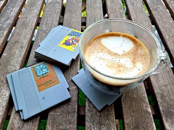 reviewer's mug on coaster with zelda and super mario cartridge shaped ones next to it