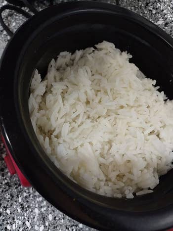 a reviewer photo of fresh cooked rice made in the rice cooker in red