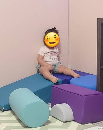reviewer image of a child sitting atop one of the foam blocks