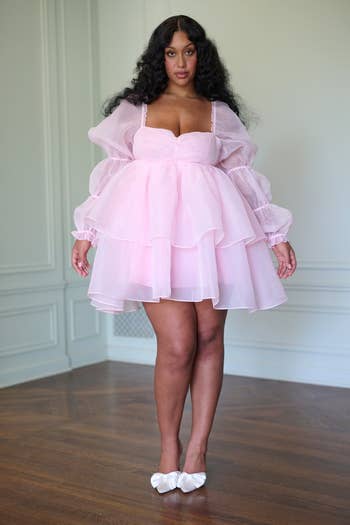model in a layered pink puff-sleeve dress and bow-adorned heels