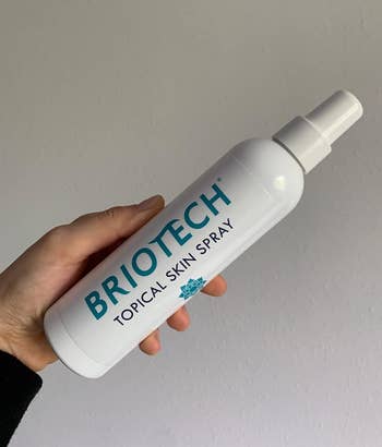 Reviewer holding their Briotech spray bottle