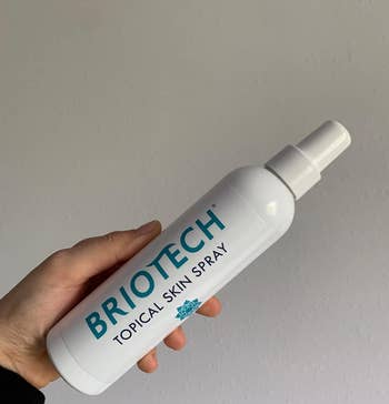 Reviewer holding their Briotech spray bottle