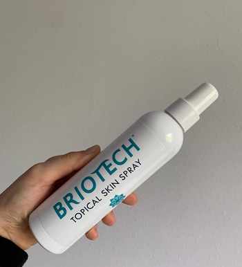 Reviewer holding their Briotech spray bottle