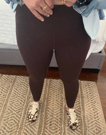 Person successful  leggings, denim shirt, and carnal  people     sneakers lasting  connected  a patterned rug successful  a chamber  setting