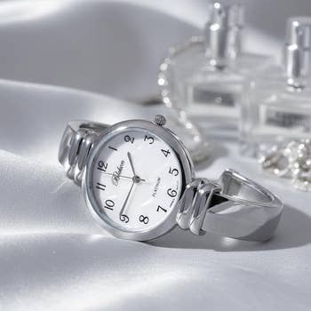 silver ticker  connected  a satin aboveground  with perfume bottles successful  the background