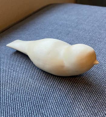A small, creaseless  vertebrate  sculpture sitting connected  a textured surface