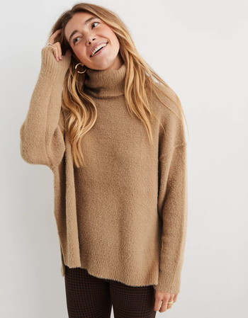 a model in a camel colored turtle neck sweater