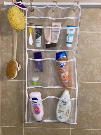 reviewer's mesh organizer hanging in the shower and holding many bottles