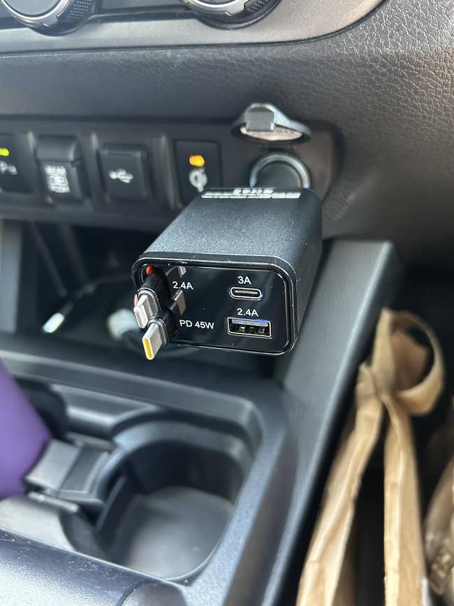 Car USB charger plugged into a conveyance  dashboard, featuring aggregate  ports with varying amp outputs for charging physics  devices