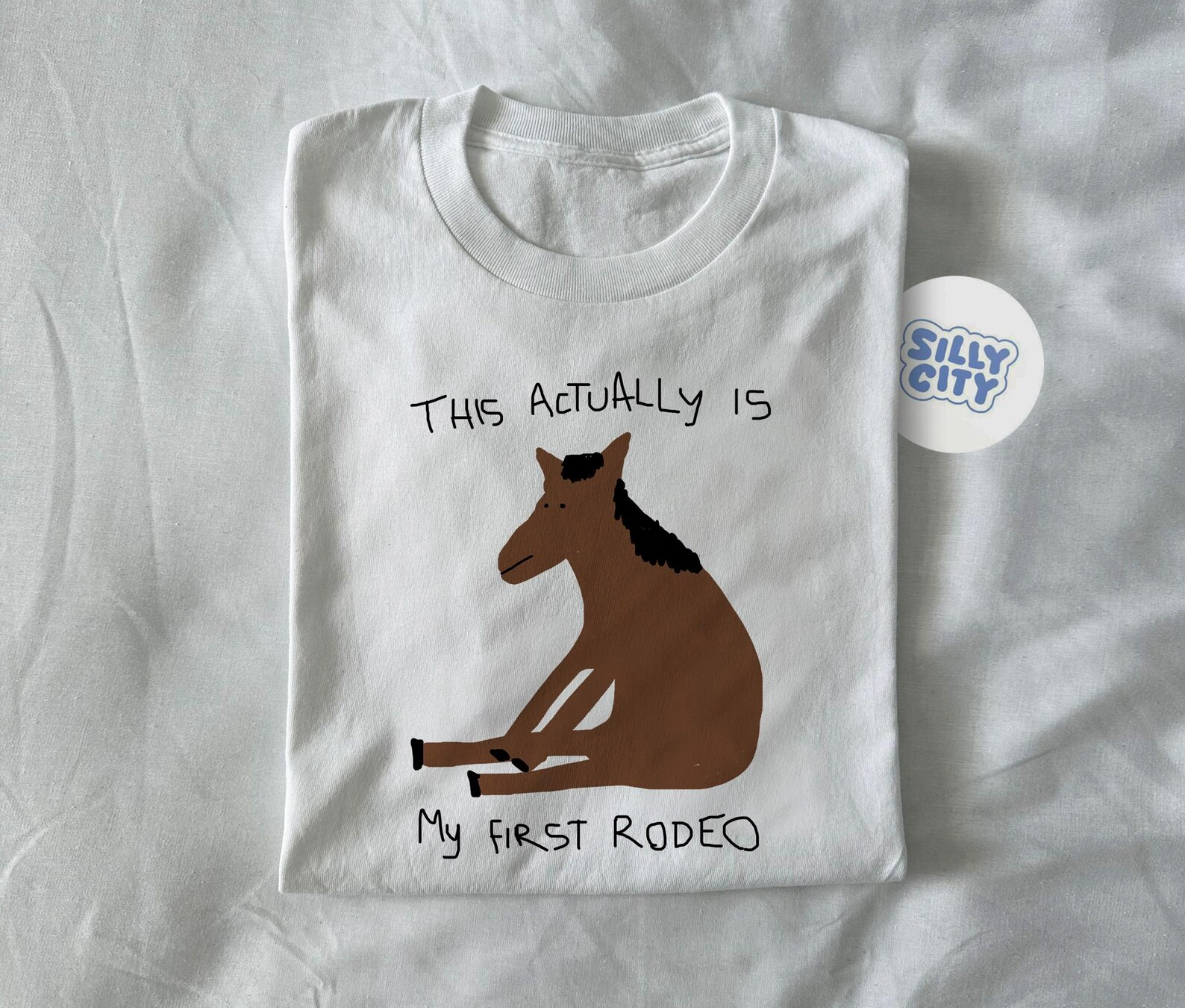 A white shirt with a horse drawn on it that says 