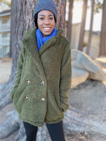 a reviewer wearing the green jacket in a button over style
