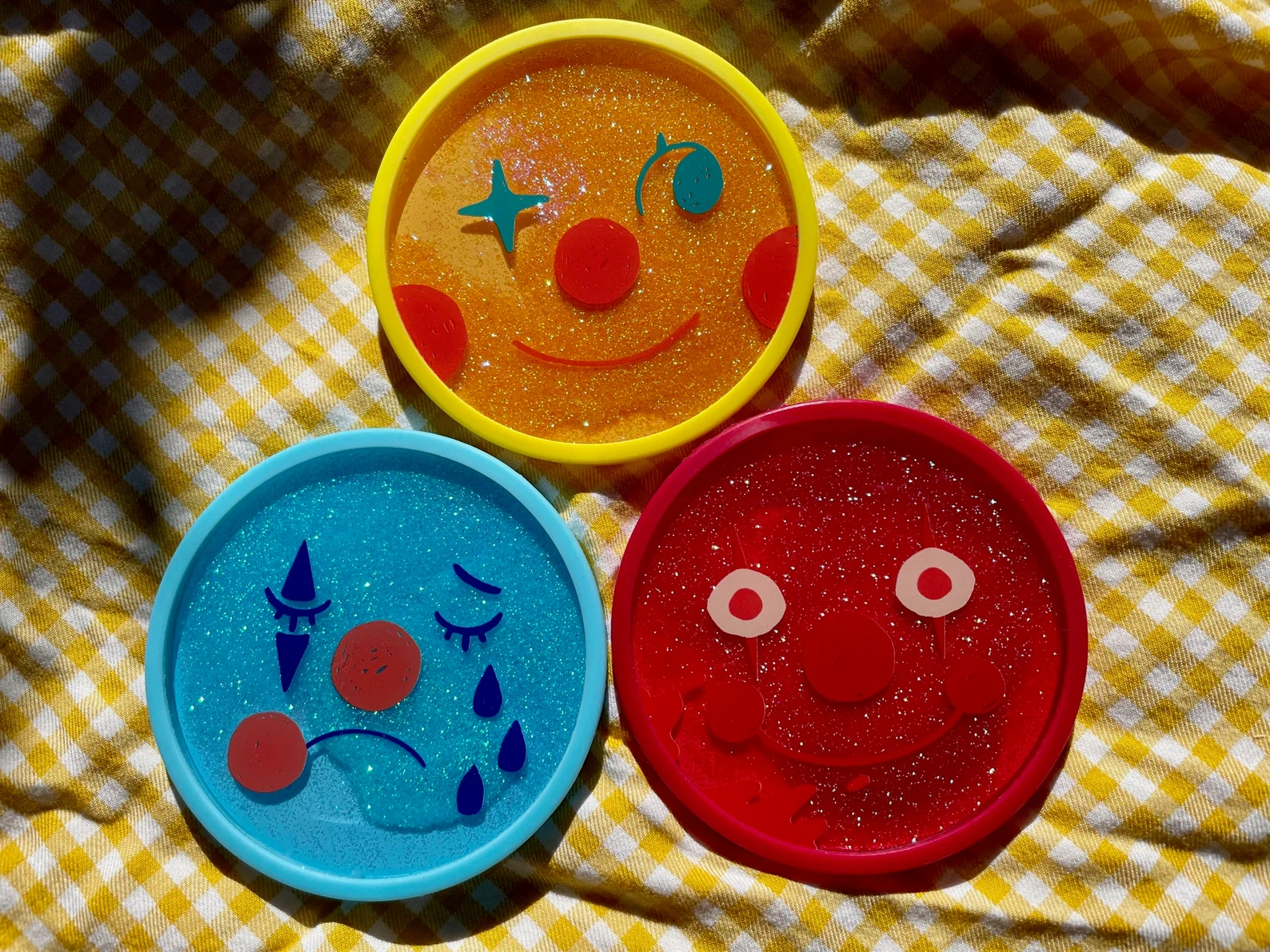 three sparkly coasters with antithetic  emotions
