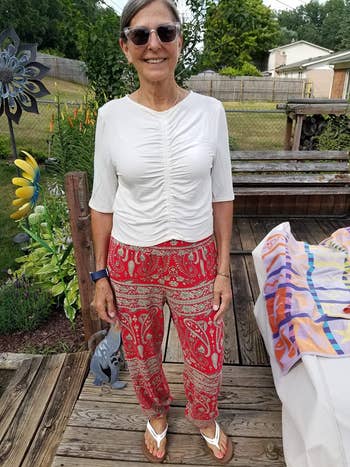 a reviewer wearing the printed pants in red 