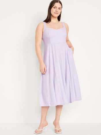 Woman in a sleeveless midi dress with a square neckline, standing pose for shopping ad