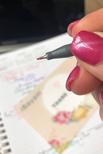 close up of the tip of one of the colored pens in a reviewer's hand