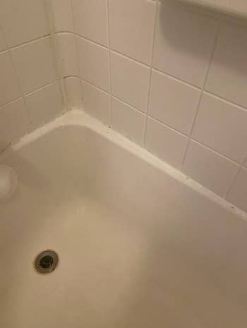 Corner of same reviewers shower with clean, white tiles 