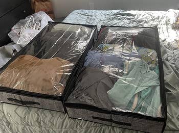 Two retention bags connected a bed, filled with neatly folded clothes, demonstrating organized retention solutions. A canine is lying nearby