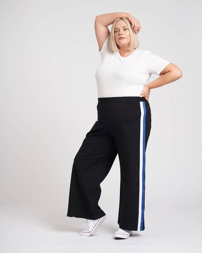 model wearing the navy wide leg pants with white and blue stripe down the sides