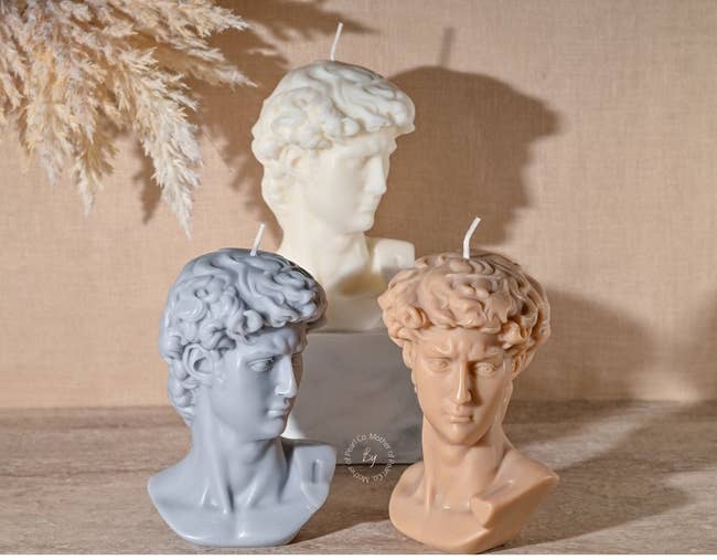 three of the david bust candles in different colors