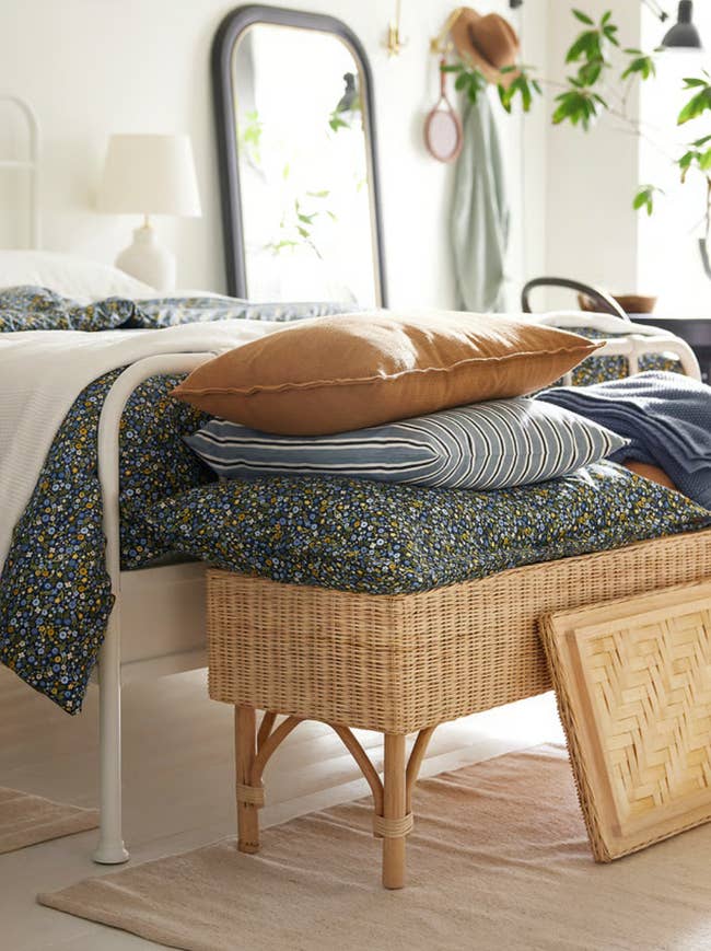 Cozy chamber  country   with a rattan bench, stacked pillows, and floral bedding; perfect  for a relaxed and inviting location  decor