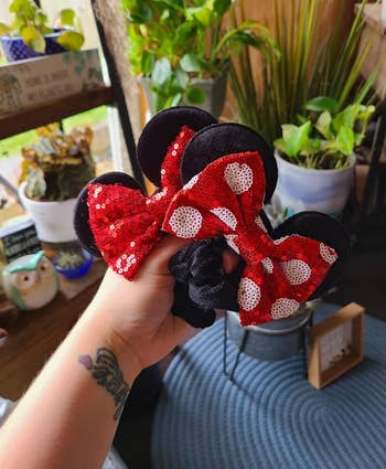 Person holding Minnie Mouse scrunchies 