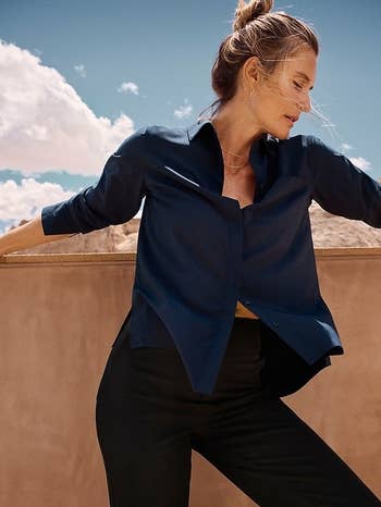 Model in chic navy blouse and black trousers