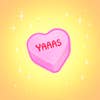 一个小小的心形糖果，上面简单地写着“yaaas”。