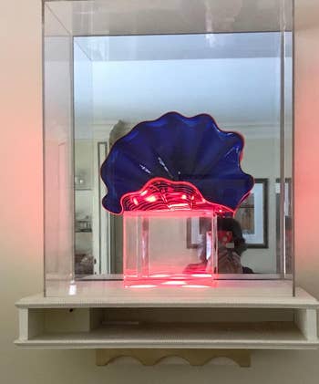 reviewer photo of a blue and pink glass sculpture on display on a floating shelf
