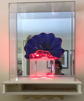 reviewer photo of a blue and pink glass sculpture on display on a floating shelf