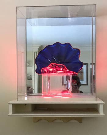 reviewer photo of a blue and pink glass sculpture on display on a floating shelf
