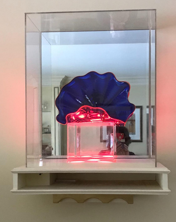 reviewer's blue and pink glass sculpture on display on a floating shelf