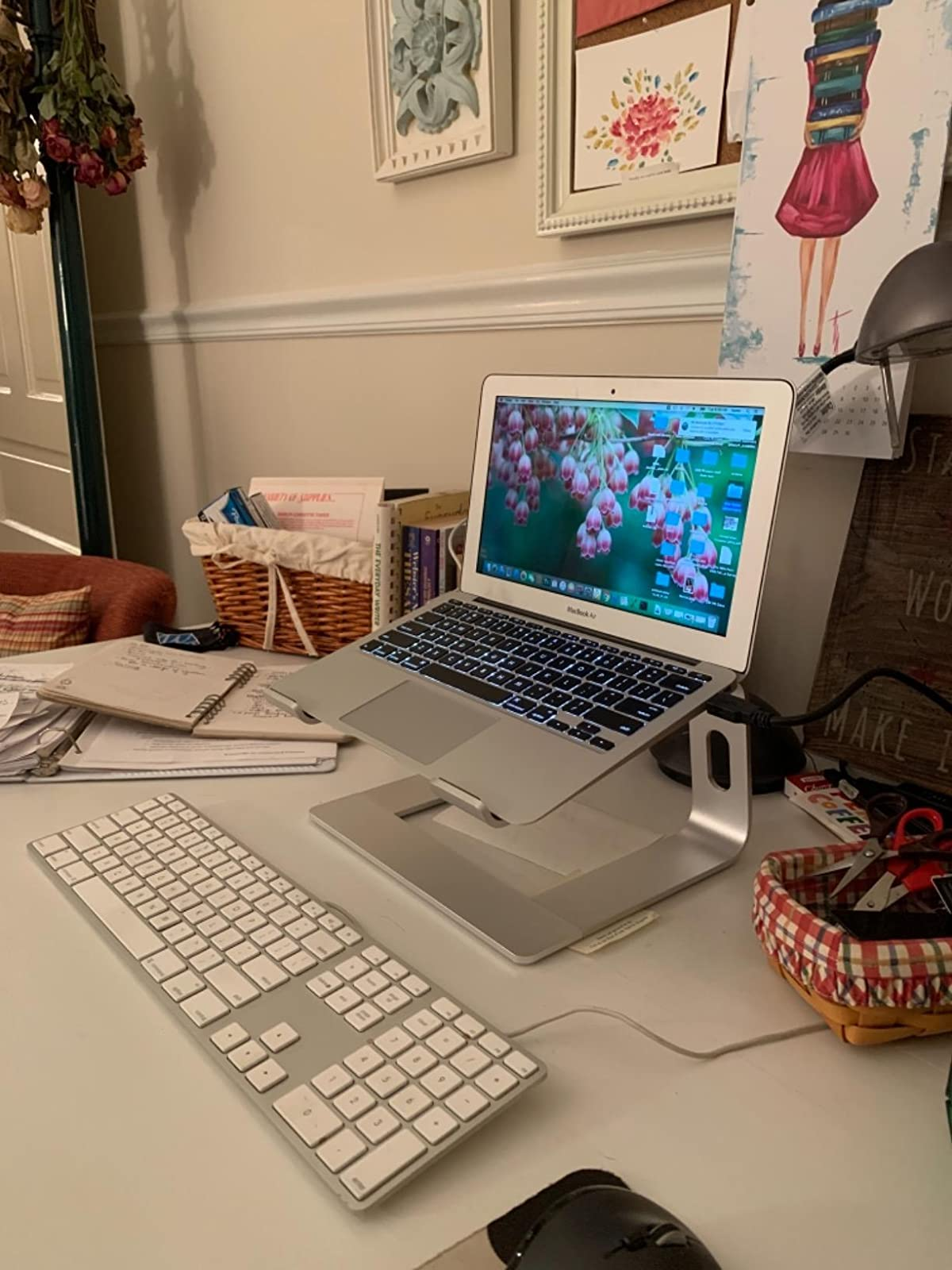 A reviewer's laptop resting on the stand on a desk 