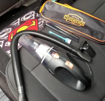 a reviewer photo of the portable vacuum, travel case, and included detail attachments 