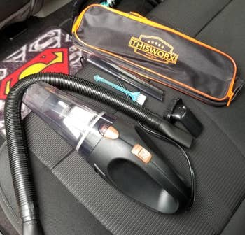 a reviewer photo of the portable vacuum, travel case, and included detail attachments 