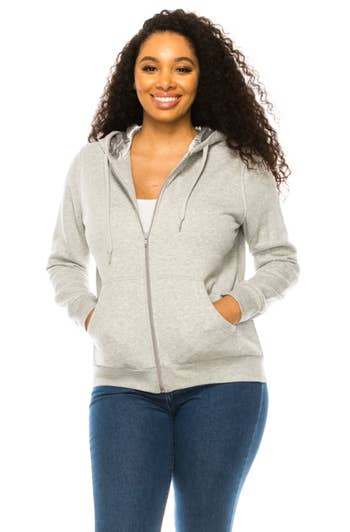 a model wearing the light grey zip up showing the grey satin inside the hood
