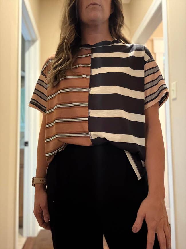 Person wearing a short-sleeve garment with mixed horizontal stripe patterns lasting successful a hallway