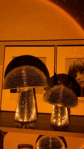 Video of different sized mushroom disco balls glimmering in a dark room