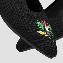 black flats with toucan embroidery on toes
