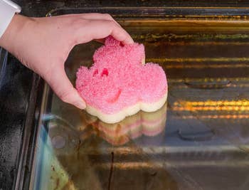 hand utilizing Minnie Mouse-shaped Scrub Daddy Sponge