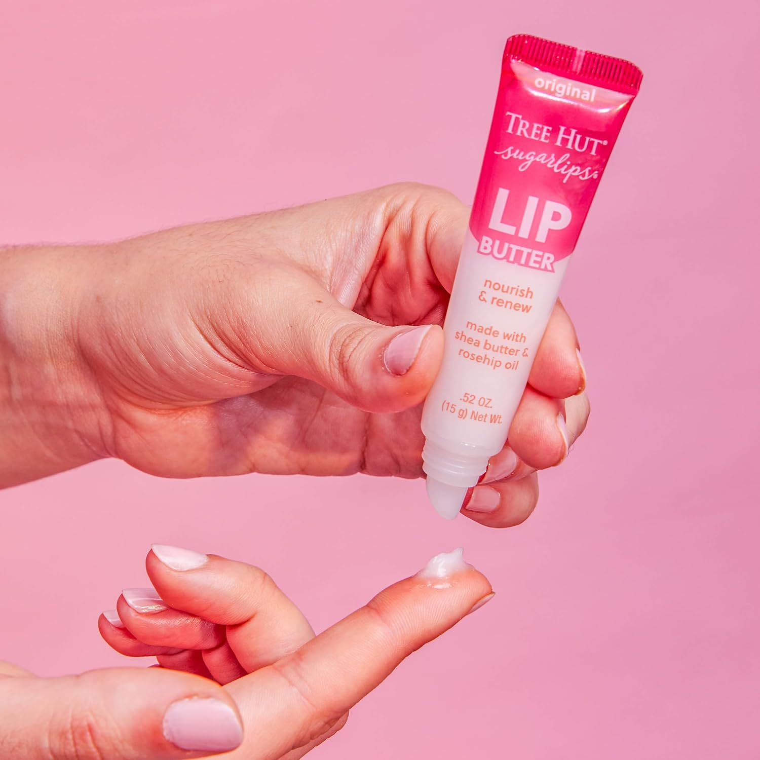 Hands applying Tree Hut Sugarlips Lip Butter, made with shea butter and rosehip oil