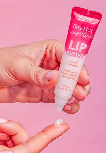 Hands applying Tree Hut Sugarlips Lip Butter, made with shea butter and rosehip oil