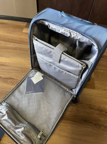 reviewer's suitcase open so you can see a large mesh pocket and large compartment