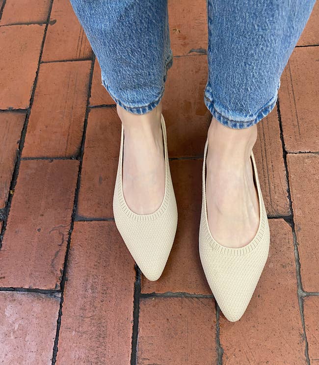 A pair of pointed toe cream colored flats 