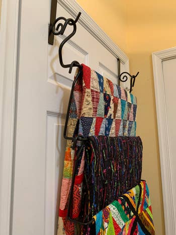 Three quilts hung on the over-the-door hanger, side view
