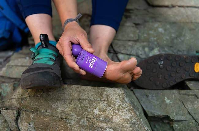 model applying merchandise to feet from deodorant-like tube