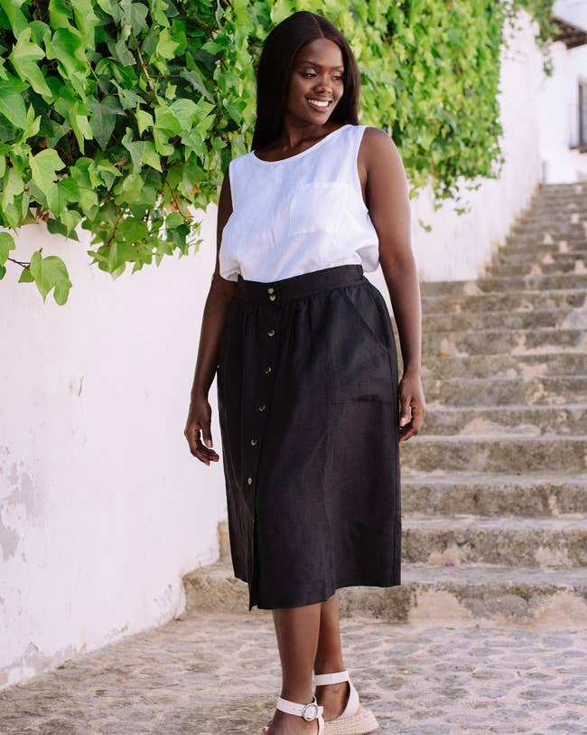 model wearing button down linen skirt in black