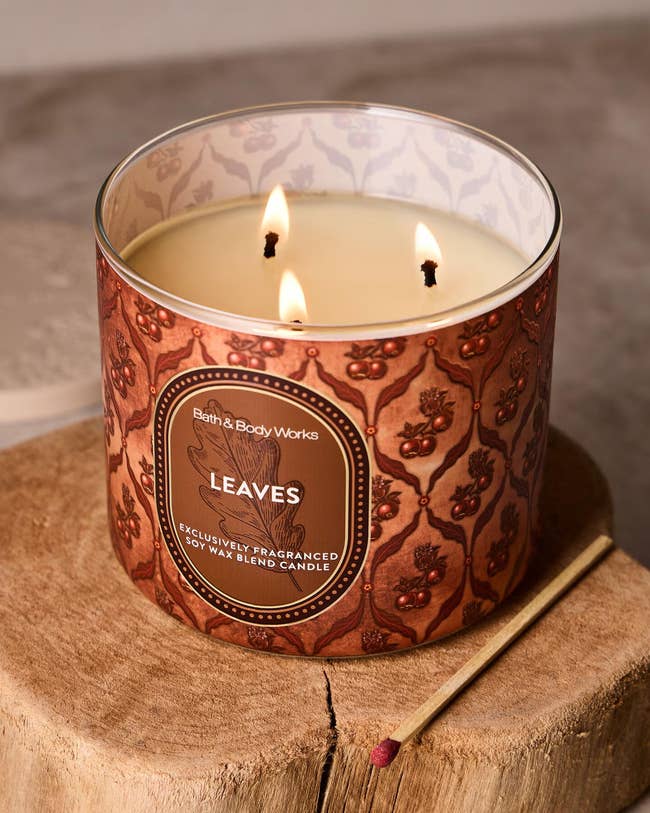 A lit Bath & Body Works candle labeled