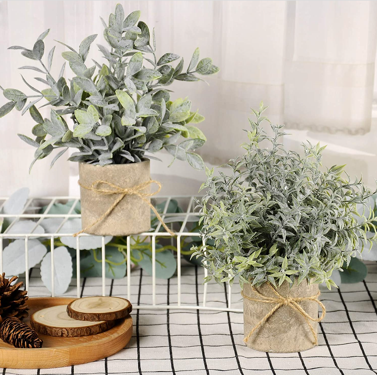 Two fake plants on a counter